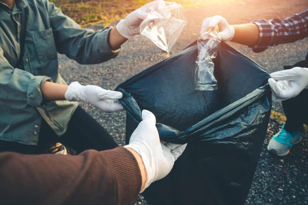 Volunteers in gloves collecting trash