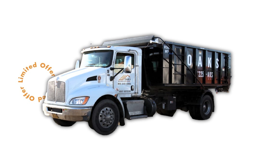 A large blue dump truck with a black trailer. The truck has a silver grill.