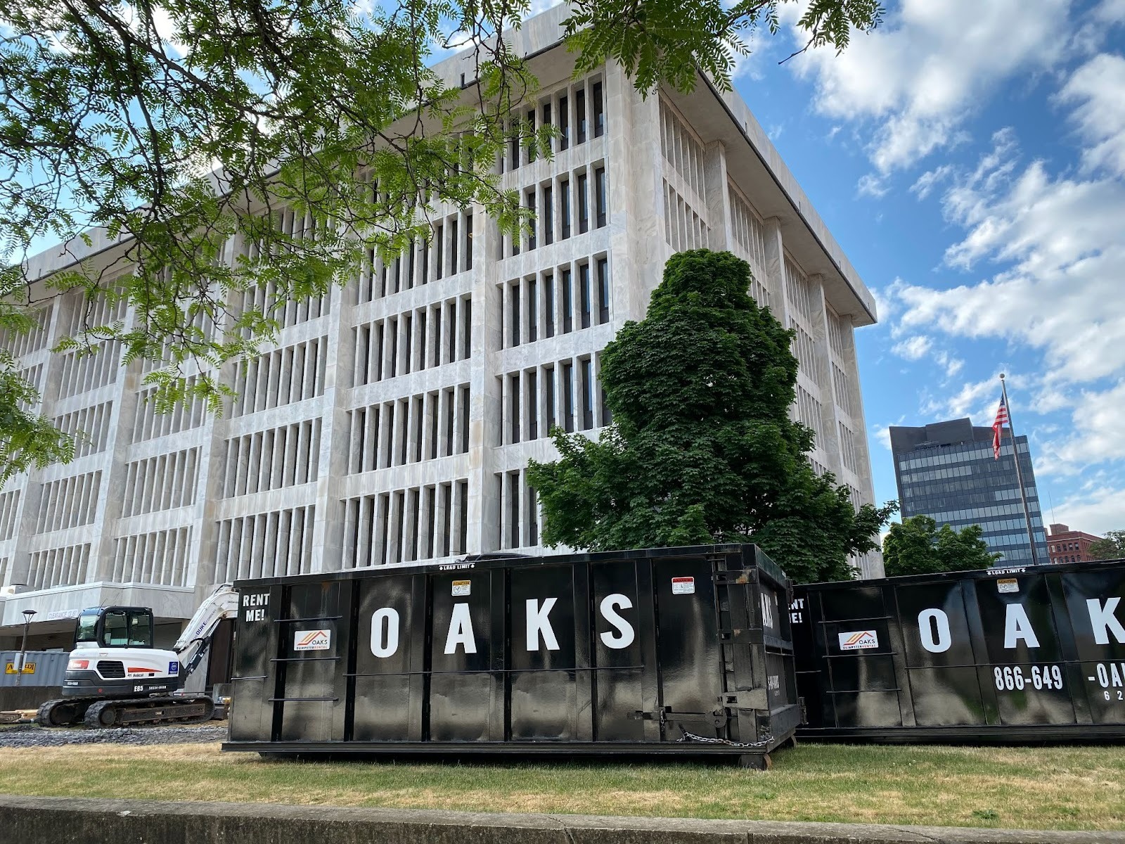 A large white building with a dumpster in front