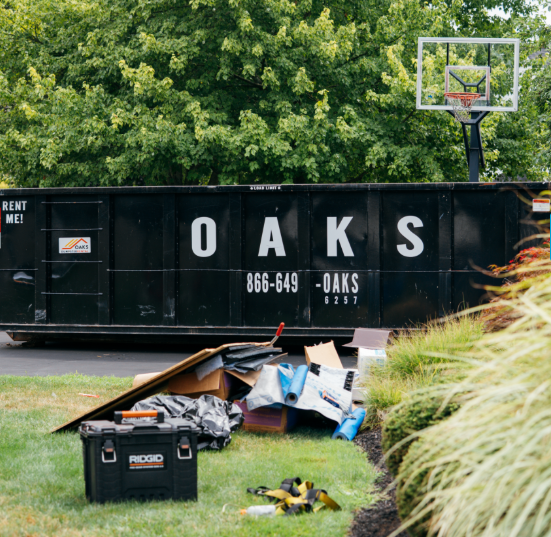 Oaks dumpster with construction debris outside. Efficient waste management.