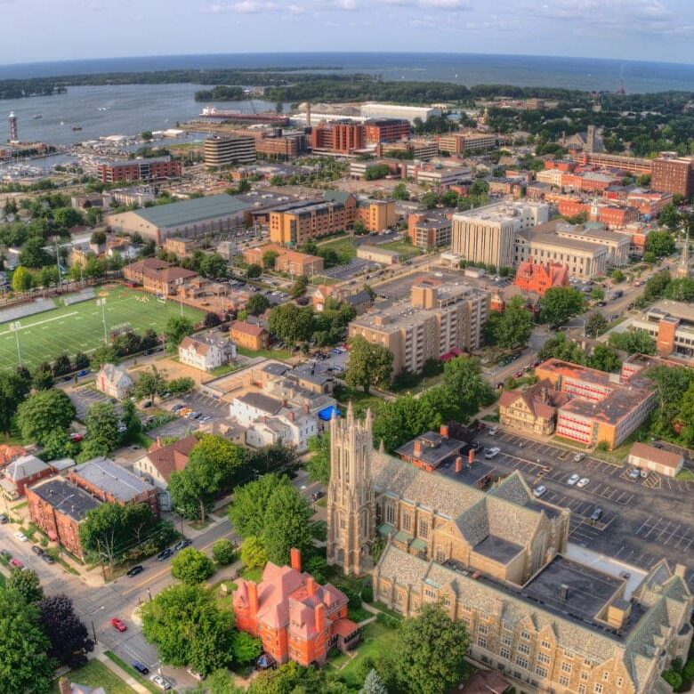 aerial view of a city with a large body of water and a football field